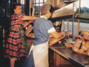 Mim Herr (right), with Mary Wowrer, packing chips by hand. (courtesy of Herr Foods)