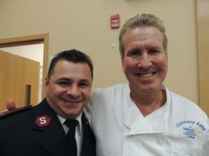 Chef Peter Gilmore (right), director of Delaware County Community College’s Culinary Arts Program, with a Coatesville Salvation Army worker.