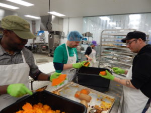 Volunteers from the Whole Foods Market in Devon help the Food Bank portion out vegetables. 