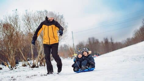 dad and kids going sledding