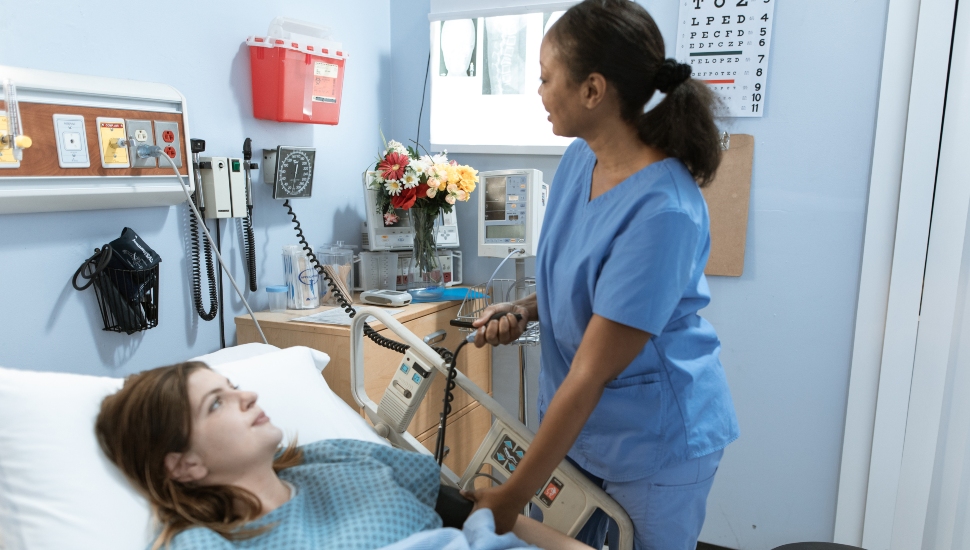 Nurse tending to a patient in bed