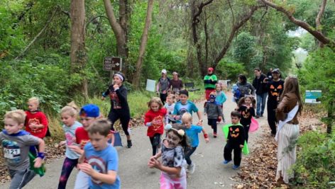 Children running in a 5K along a park path.