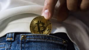 Woman slipping a Bitcoin in her pocket.