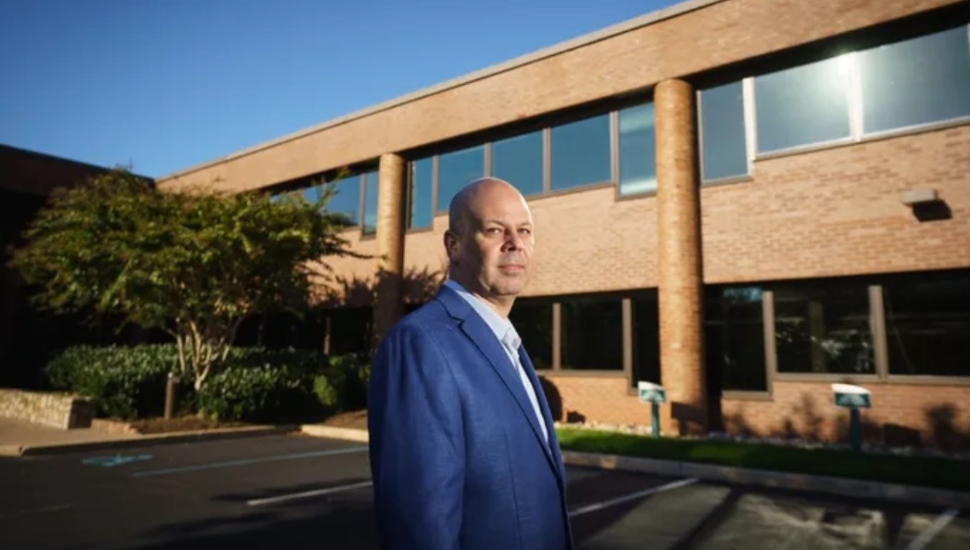man in blue coat standing with a building