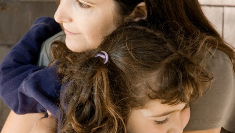 A woman hugging a young girl.