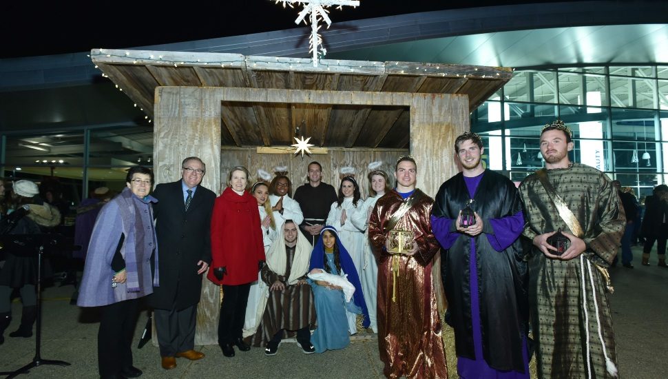 A group gathers in front of a manger scene at a past Live Nativity event at Neumann University