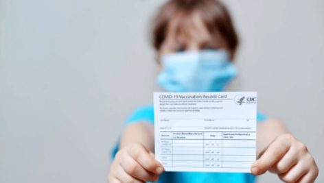 child holding vaccine card