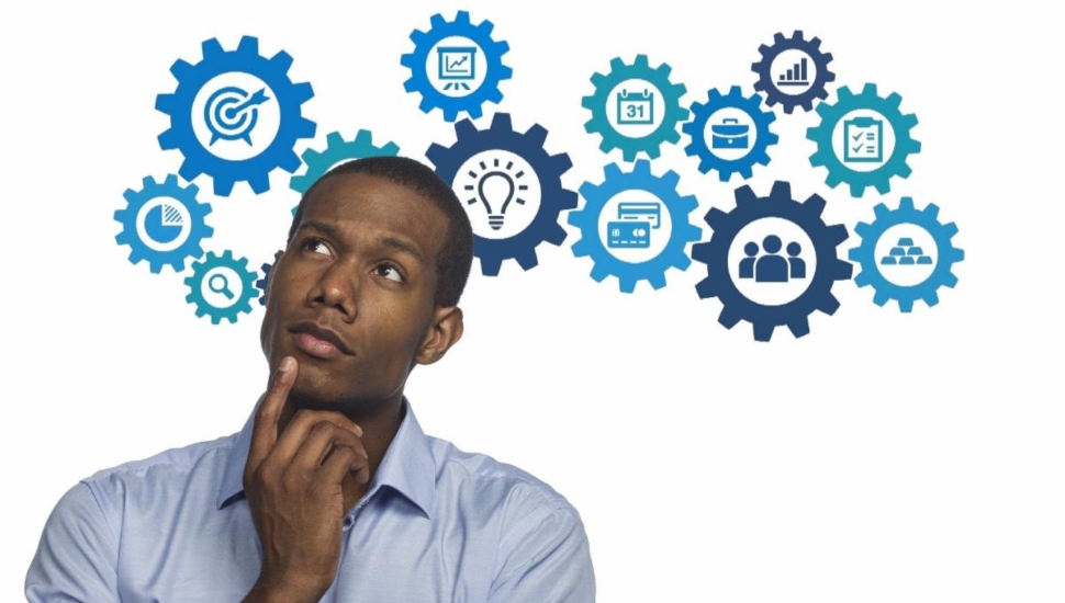 A man thinking with idea graphics above him.