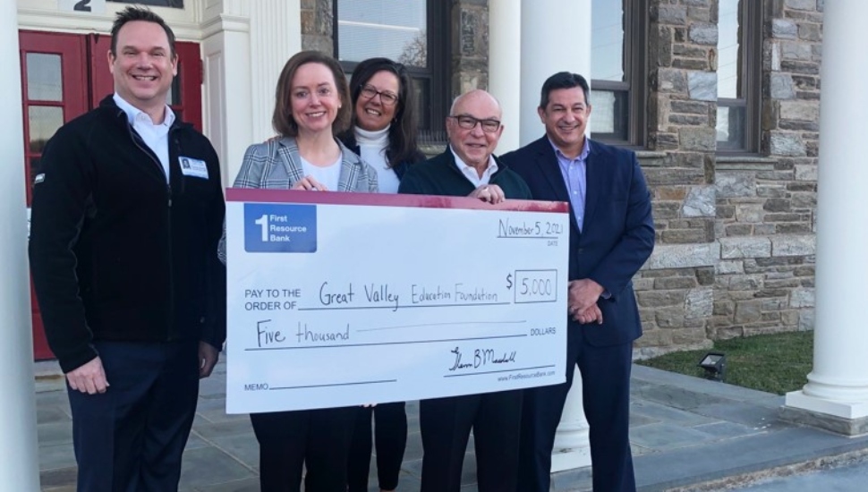 five people with a check