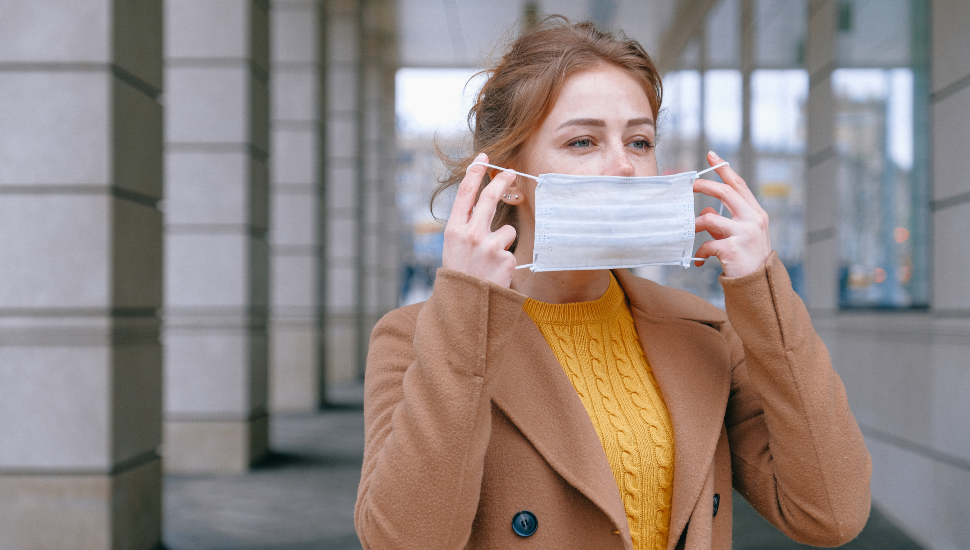 Woman putting on a facemask.