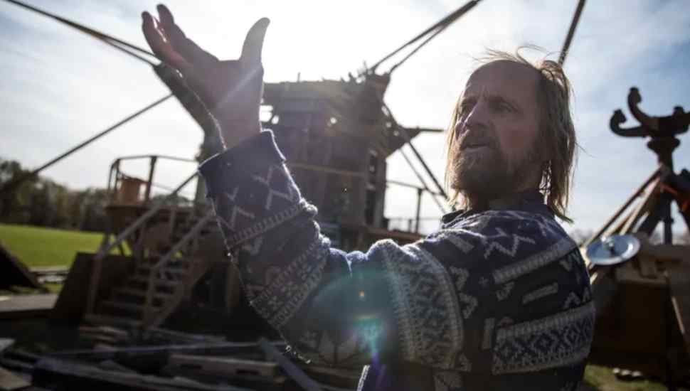 man in sweater lifting his hand