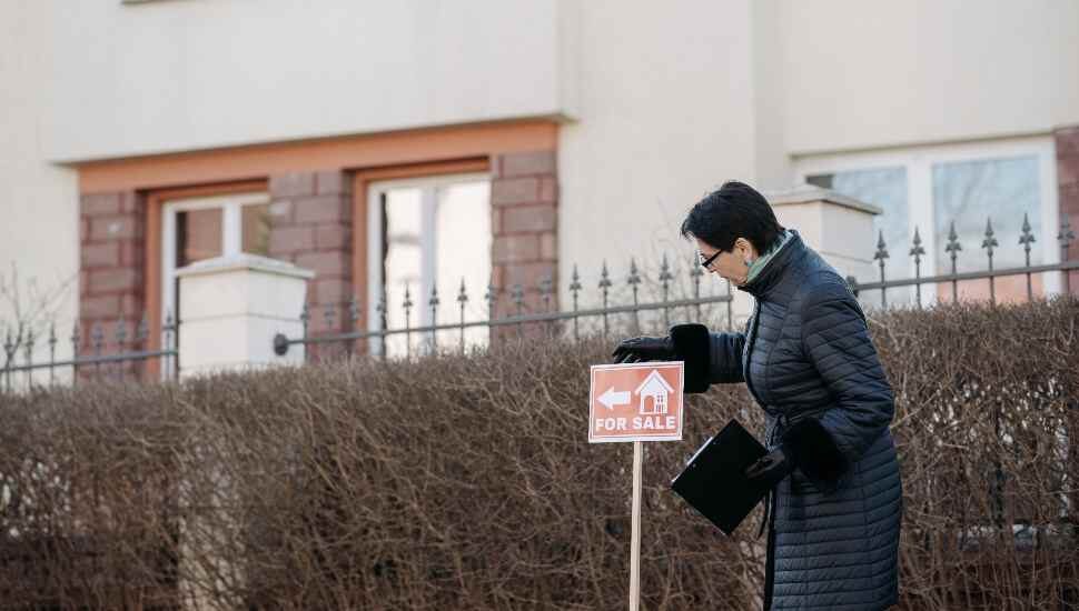 woman in a coat with a sign