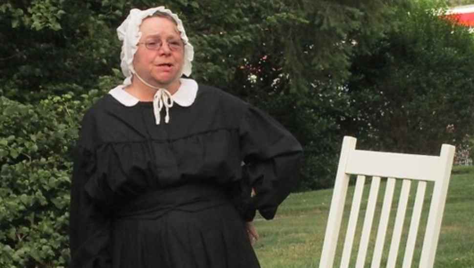 woman in black dress and white bonnet