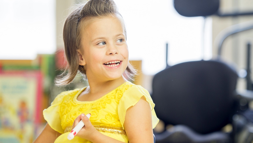 A little girl holding a magic marker.