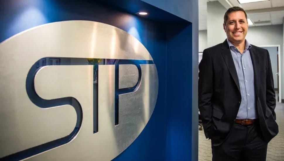 man next to STP logo
