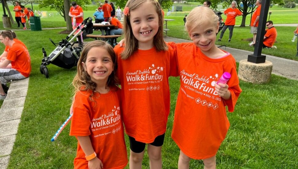 Three girls standing at the Bubble Walk & Fund Day