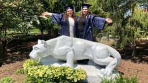 Two Penn State Brandywine students behind the Penn State Nittany Lion statue.