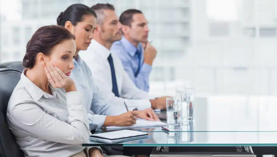 A woman suffers through a boring meeting