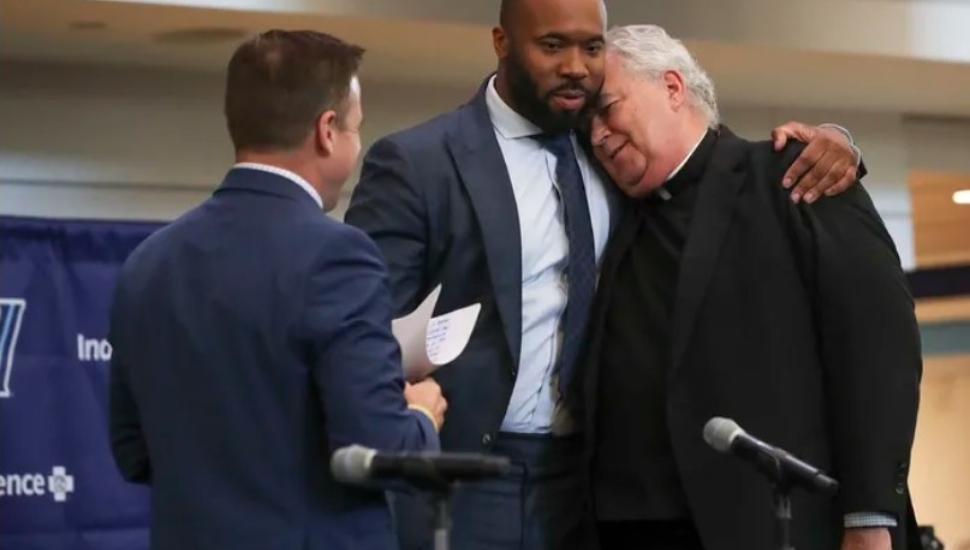 Kyle Neptune hugs Villanova president Peter Donohue at a press conference introducing him.