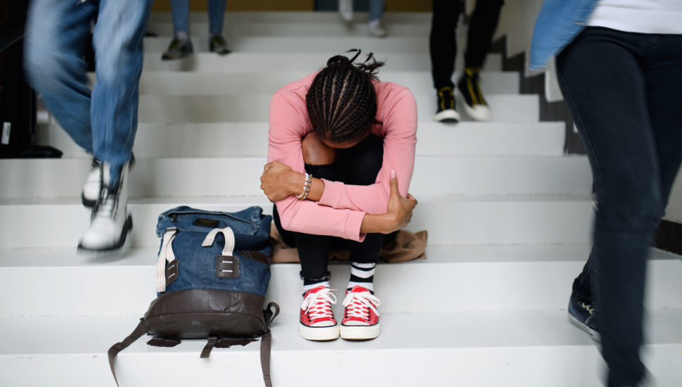 girl sits alone on school steps