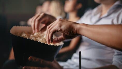 people eating popcorn while watching a film