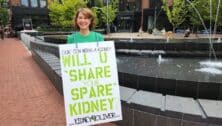 Tammy Mayer holding up a sign looking for a kidney for her son