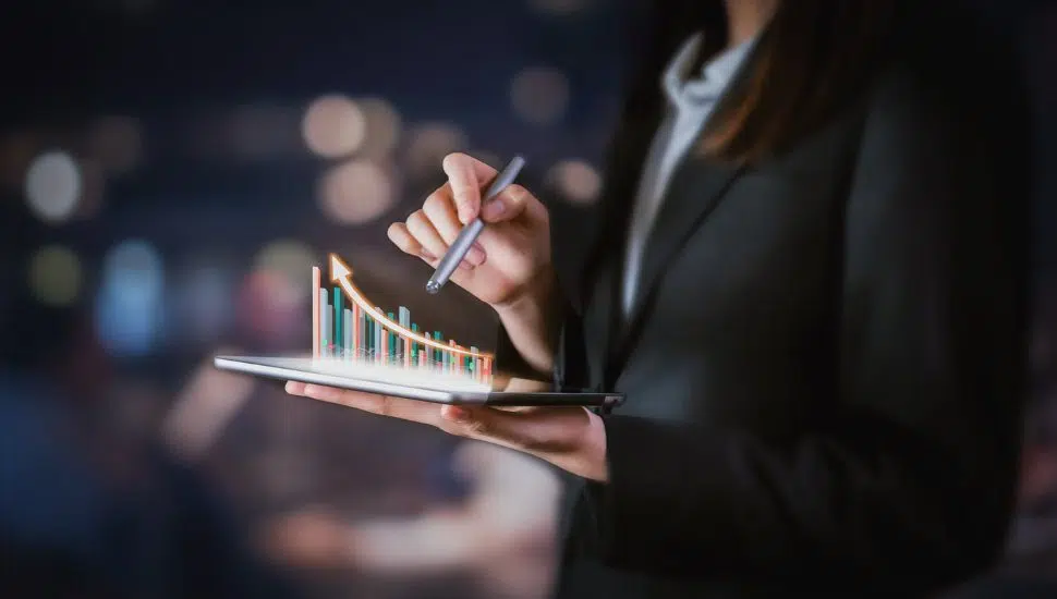 person holding tablet with graphic indicating company growth