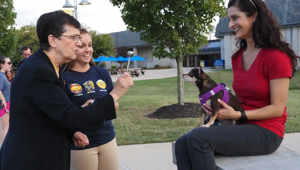 Sr. Marguerite O'Beirne blesses the furry friend of Preeti Singh in 2019.