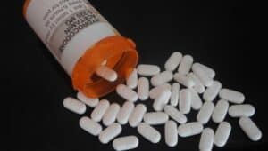 orange prescription with white pills falling out