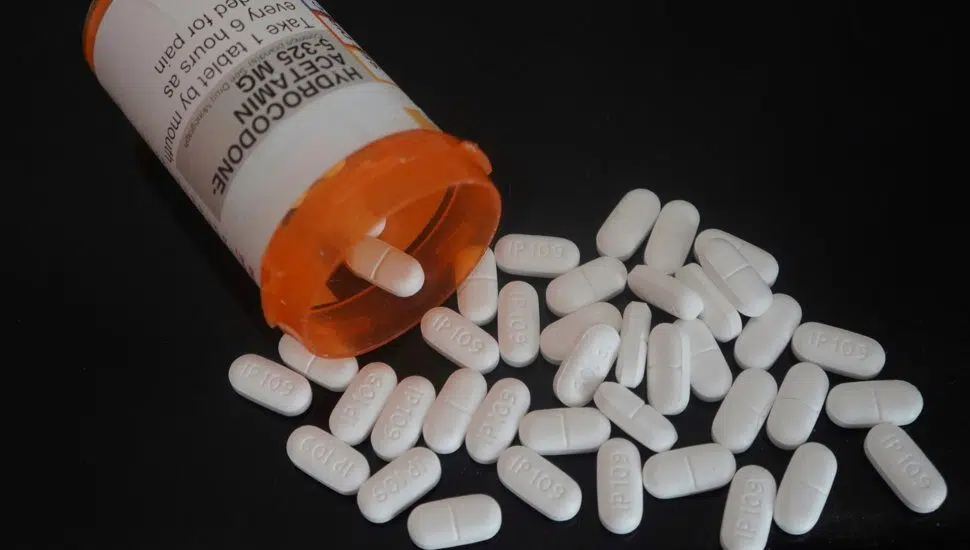 orange prescription with white pills falling out