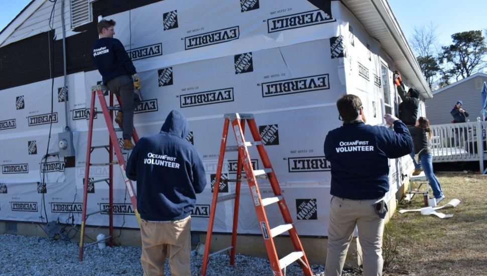 OceanFirst volunteers work on the exterior of a home