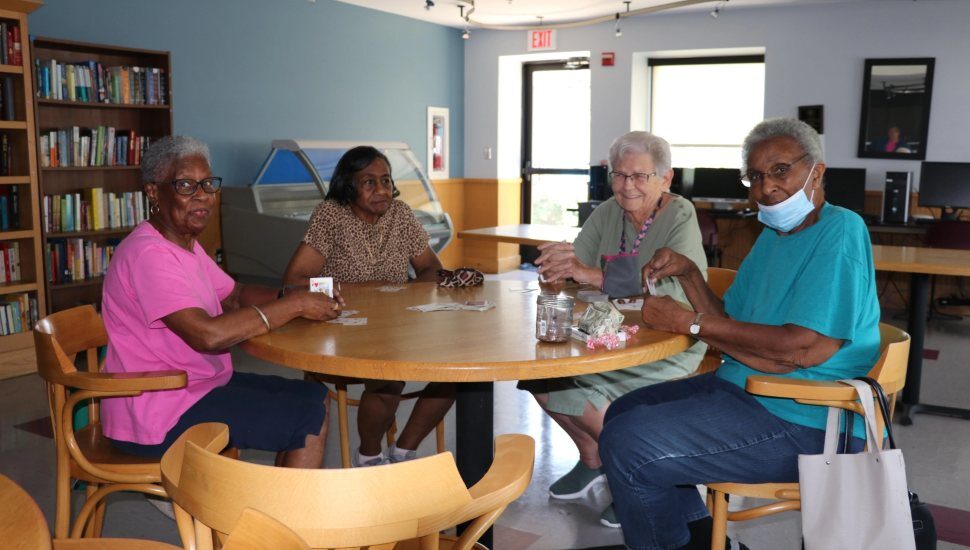 group of senior-age women playing cards at table