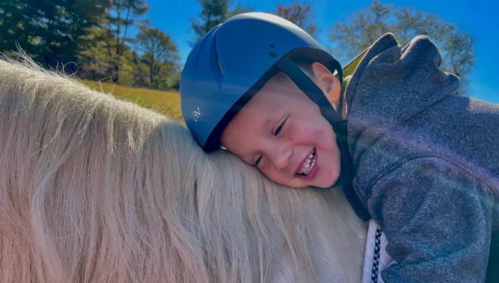 Asher McGrath on a horse with Reins for Life program