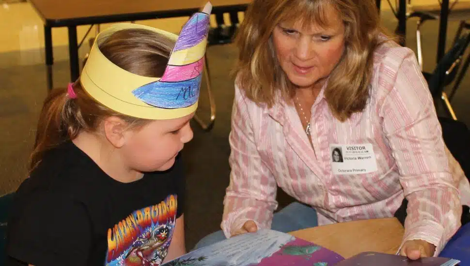 woman reading to a little girl