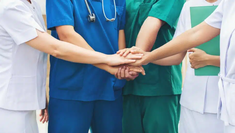 hospital team stacking hands together