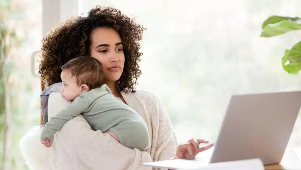 Woman holding a baby while working