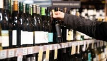 person searching shelves at liquor store