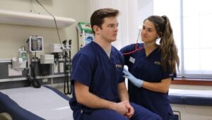 A female nursing student performs a hands-on assessment on a male classmate in the nursing simulation lab at Widener University
