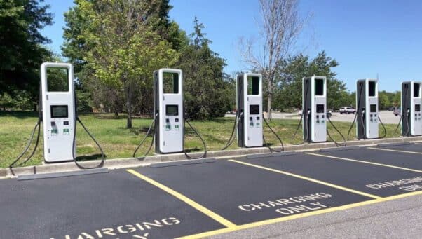 electric charging station with many electric chargers and a parking lot on a sunny day