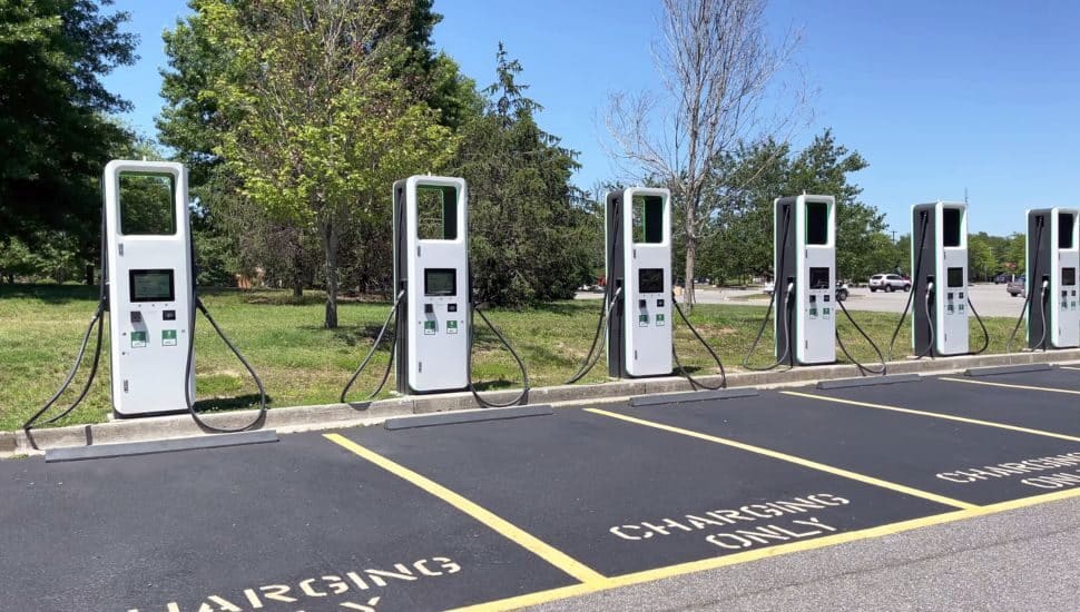 electric charging station with many electric chargers and a parking lot on a sunny day