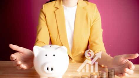 Businesswoman with rows of coins with graph for finance and business concept. coins with piggy bank. S