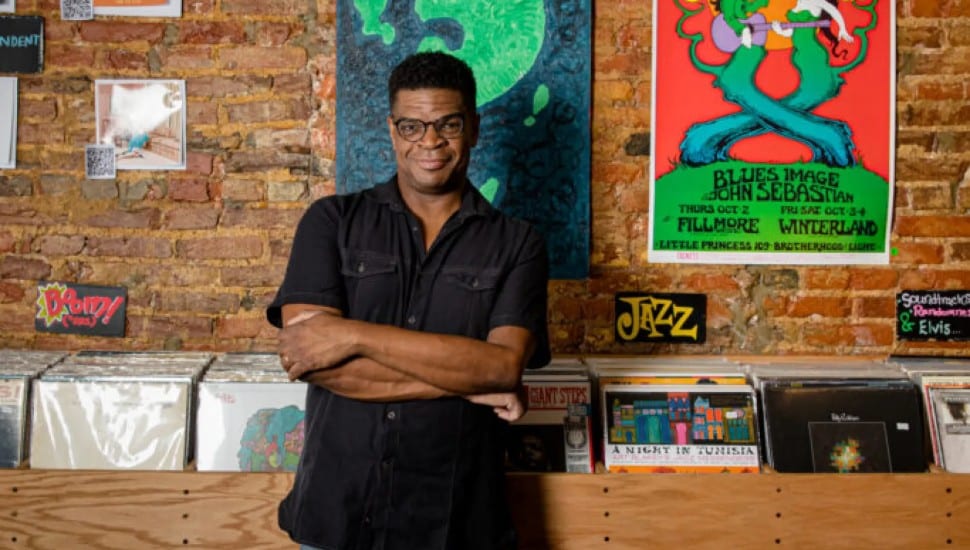Shawn Cephas in front of the jazz section at his record store.