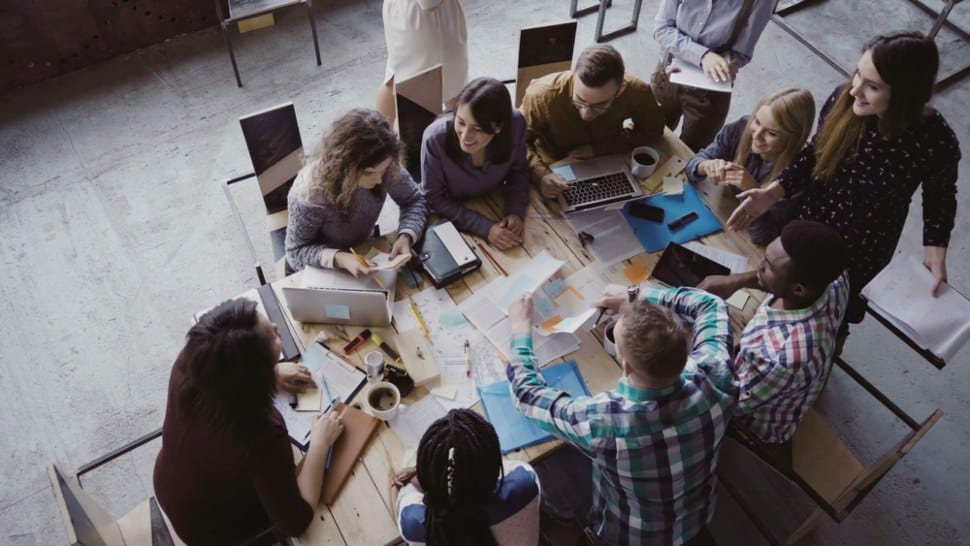 Young people gathered around a table talking and sharing time together