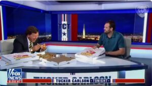 Tucker Carlson of Fox News shares some pizza on his news show with Tyler Morrell, the pizza delivery driver who tripped a suspect in a stolen car police chase