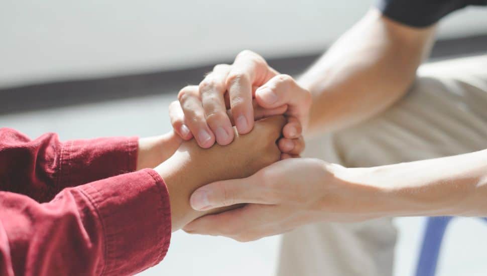 person comforting teen with hands