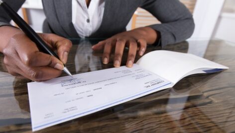 Woman signing a business check