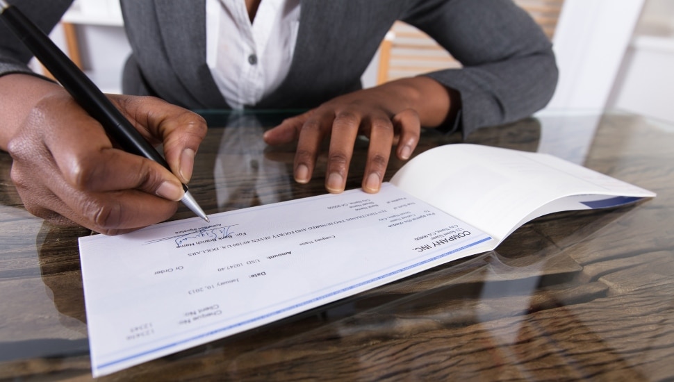 Woman signing a business check
