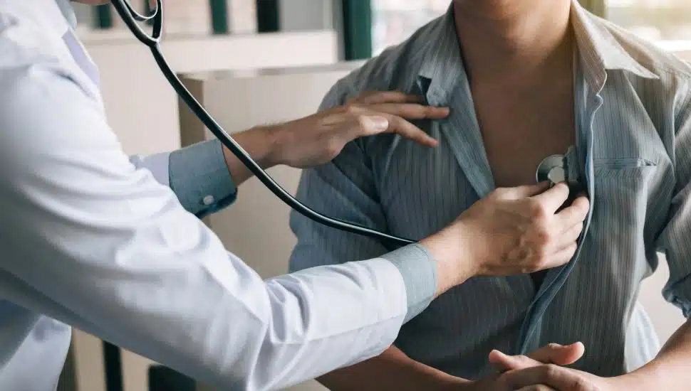 doctor using stethoscope on patient