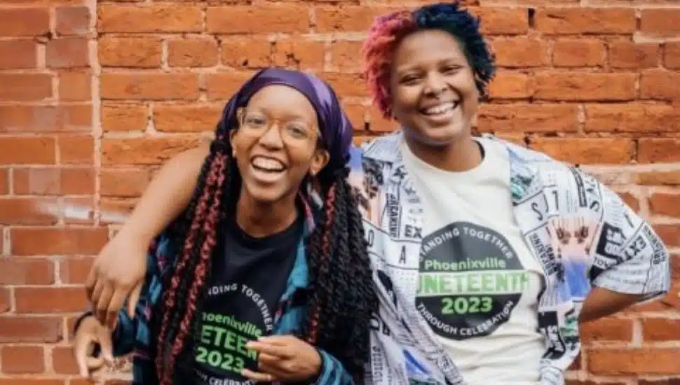two people smiling brick wall background