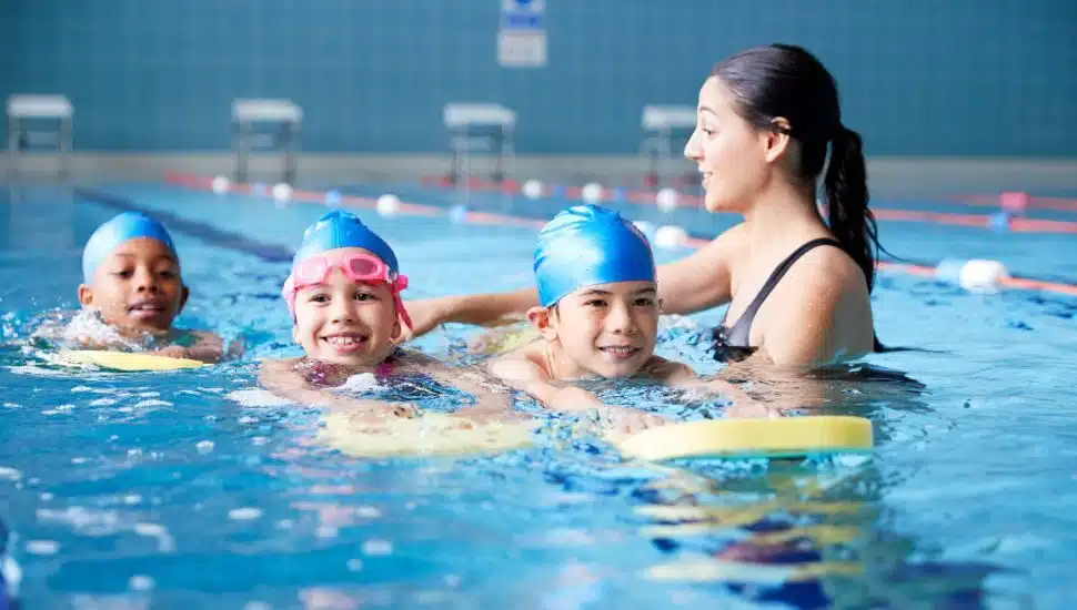 kids learning how to swim in a pool